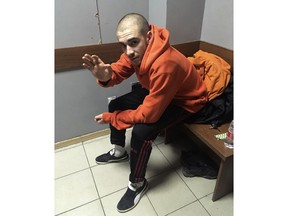 In this photo taken by Alexey Avanesyan, Alexander Kuznetsov, Russian rapper also known as Husky gestures as he waits for a court hearing in Krasnodar, Russia, Thursday, Nov. 22, 2018. The Russian rapper is facing two weeks in jail for performing on a car after prosecutors banned his gig for going against the government. (Alexander Avanesyan via AP)