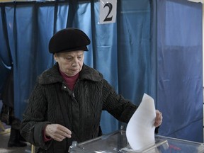 A woman casts her ballot at a polling station during rebel elections in Donetsk, Ukraine, Sunday, Nov. 11, 2018. Residents of the eastern Ukraine regions controlled by Russia-backed separatist rebels are voting for local governments in elections denounced by Kiev and the West. (AP Photo)