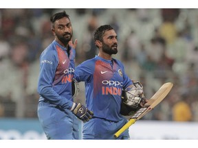 India's Dinesh Karthik, right, and Krunal Pandya leave the field after their win over West Indies in the first Twenty20 international cricket match between India and West Indies in Kolkata, India, Sunday, Nov. 4, 2018.