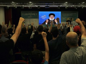 Supporter of the Iranian-backed Hezbollah group raise their fists and cheer as they listen to a speech of Hezbollah leader Sayyed Hassan Nasrallah, via a video link, during a rally marking Hezbollah Martyr's Day, in a southern suburb of Beirut, Lebanon, Saturday, Nov. 10, 2018.