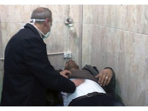 In this photo released by the Syrian official news agency SANA, shows a man receiving treatment at a hospital following a suspected chemical attack on his town of al-Khalidiya, in Aleppo, Syria, Saturday, Nov. 24, 2018. At least 41 civilians were being treated following a suspected poison gas attack by Syrian rebel groups on government-held Aleppo city in the country's north, according to Syrian state media. (SANA via AP)
