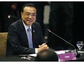 Chinese Premier Li Keqiang smiles as he glances at ASEAN leaders after delivering his statement at the ASEAN Plus China Summit in the ongoing 33rd ASEAN Summit and Related Summits Wednesday, Nov. 14, 2018 in Singapore. China's premier sought Tuesday to reassure its neighbors that Beijing will push ahead with reforms needed to support growth across the region and also keep the peace in contested waters in the South China Sea.