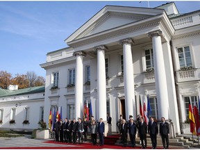 Polish Prime Minister Mateusz Morawiecki, center right, welcomes German Chancellor Angela Merkel, center left, ahead of intergovernmental consultations at the Belvedere Palace in Warsaw, Poland, Friday Nov. 2, 2018. Merkel is visiting Warsaw amid calls by Polish officials that Germany pay Poland billions of dollars for damage inflicted by the Nazis during World War II.