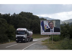 In this Sept. 7, 2018 file photo, a truck passes by a billboard that reads: '"Welcome, President" and shows Serbian President Aleksandar Vucic, near village of Lesak in northern Kosovo. Kosovo's government has decided to introduce a 100 percent import tax on all goods imported from Serbia and Bosnia Herzegovina.