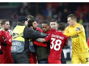 Spartak's Luiz Adriano, center, discusses with a fan who entered in the field during a Group G Europa League soccer match between Spartak Moscow and Rapid Wien at the Spartak Stadium in Moscow, Russia, Thursday, Nov. 29, 2018.