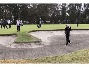 Tyrrell Hatton of England, bottom right, plays out a fairway bunker on the first hole during the second round of the World Cup of Golf tournament at the Metropolitan Golf Club in Melbourne, Australia, Friday, Nov. 23, 2018. Hatton and his partner, Ian Poulter, are playing South Korea's Byeong Hun An and Si Woo Kim.