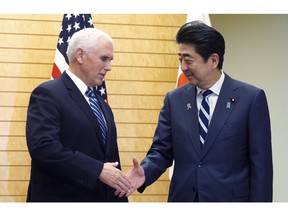 U.S. Vice President Mike Pence, left, and Japanese Prime Minister Shinzo Abe shake hands at Abe's official residence in Tokyo Tuesday, Nov. 13, 2018.