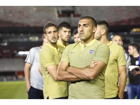 Ramón Abila of Argentina's Boca Juniors waits with his team on the pitch of the Antonio Vespucio Liberti stadium after the final soccer match of the Copa Libertadores was rescheduled for Sunday, in Buenos Aires, Argentina, Saturday, Nov. 24, 2018. The match was rescheduled after the bus carrying the Boca Juniors players was attacked by River Plate fans, injuring several players including Perez.