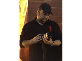 In this Nov. 3, 2014 photo, Jawad Nasrallah, the second eldest son of of Hezbollah leader Sheikh Hassan Nasrallah, adjusts his camera during a speech by his father, in the southern suburb of Beirut, Lebanon. Jawad designated by the U.S. State Department this week as a "global terrorist" is a poet and music lover who moves around without security and whose role within the group is shrouded in secrecy.