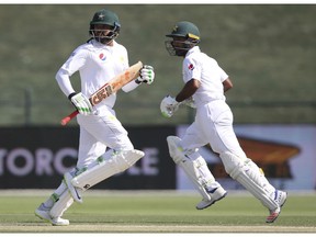 Pakistan's Azhar Ali, left, and Asad Shafiq run between wickets in their cricket test match against New Zealand in Abu Dhabi, United Arab Emirates, Monday, Nov. 19, 2018.