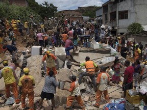 Residents, volunteers and firefighters work over the debris after a mudslide in Boa Esperanca or "Good Hope" shantytown in Niteroi, Brazil, Saturday, Nov. 10, 2018. Several people were killed and others injured in a mudslide near Rio de Janeiro on Saturday, Brazilian authorities said.