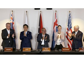 From left, Australian Prime Minister Scott Morrison, Japanese Prime Minister Shinzo Abe, Papua New Guinea's Prime Minister Peter O'Neill, New Zealand's Prime Minister Jacinda Ardern and U.S. Vice President Mike Pence applaud during a signing ceremony for the Papua New Guinea Electrification Partnership at APEC Haus in Port Moresby, Papua New Guinea, Sunday, Nov. 18, 2018.