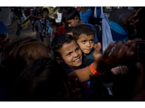 Children, part of the migrant caravan, ask for sweets at a shelter in Tijuana, Mexico, Wednesday, Nov. 21, 2018. Migrants camped in Tijuana after traveling in a caravan to reach the U.S are weighing their options after a U.S. court blocked President Donald Trump's asylum ban for illegal border crossers.