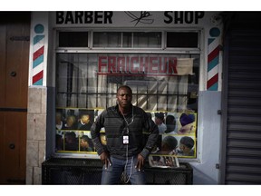 Philocles Julda, 44, poses for a photo in front of a Haitian barbershop in Tijuana, Mexico, Thursday, Nov. 22, 2018. Julda is part of a group of Haitian immigrants who started the Association of the Defense of Haitian Migrants to give the community a place to help itself with everything from Spanish lessons to paying medical bills.