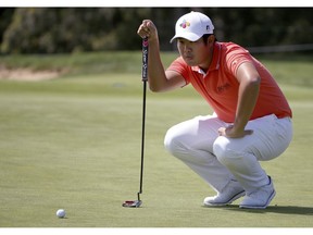 Byeong Hun An of South Korea lines up his putt on the first green during the Australian Open Golf tournament in Sydney, Thursday, Nov. 15, 2018.
