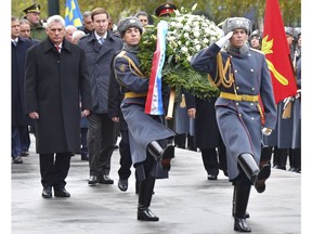Cuba's President Miguel Diaz-Canel, left, attends a wreath laying ceremony at the Tomb of the Unknown Soldier in Moscow, Russia, Friday, Nov. 2, 2018. Diaz-Canel is in Moscow for three days of talks aimed to expanding cooperation between the two nations.