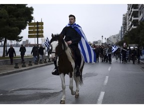 A young horseman draped in a Greek flag, leads a protest in the northern Greek city of Thessaloniki, Thursday, Nov. 29, 2018. About 1,000 high school students protested against government efforts to end a three-decade-old dispute with neighboring Macedonia.