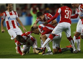 Red Star's Milan Pavkov, center, celebrates after scoring the opening goal of his team with his teammates during the Champions League group C soccer match between Red Star and Liverpool at Rajko Mitic stadium in Belgrade, Tuesday, Nov. 6, 2018.