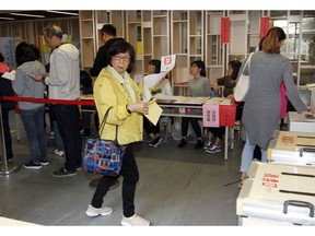 Taiwanese line up to cast their ballots at a polling station, Saturday, Nov. 24, 2018, in Taipei, Taiwan. Taiwanese began voting in midterm local elections Saturday seen as a referendum on the independence-leaning administration of President Tsai Ing-wen, amid growing pressure from the island's powerful rival China.