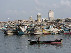 FILE - In this Friday Sept. 28, 2018 file photo, a fisherman paddles his boat past destroyed buildings on the coast of the port city of Hodeida, Yemen. Amnesty International said warned late Wednesday. Nov. 7, 2018 that Yemen's rebels have taken up positions on a hospital rooftop in the contested Red Sea city of Hodeida that a Saudi-led coalition is trying to capture. This raises concerns the Shiite rebels, known as Houthis, plan to use the patients at the Hodeida hospital as human shields to ward off airstrikes from the coalition. Amnesty is urging the warring sides to protect civilians.
