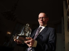 The head of BIPM (International Bureau of Weights and Measures) Martin J.T. Milton holds a replica of the International Prototype Kilogram in Sevres, near Paris.