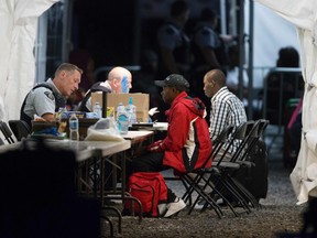 Refugees who crossed the Canada/U.S. border illegally near Hemmingford, Quebec are processed in a tent after being arrested by the Royal Canadian Mounted Police on August 5, 2017.