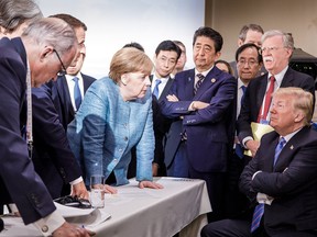 Donald Trump, right, talking with German Chancellor Angela Merkel and surrounded by other G7 leaders during a meeting of the G7 Summit in La Malbaie, Quebec, Canada.