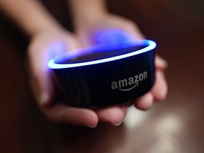 In this Thursday, Aug. 16, 2018, photo a child holds his Amazon Echo Dot in Kennesaw, Ga.