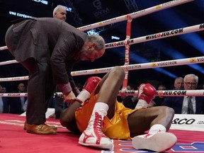 Adonis Stevenson (gold trunks) is being checked out by Marc Gagne after being knocked out by Oleksandr Gvosdyk during their WBC light heavyweight championship fight at the Videotron Centre on December 1, 2018 in Quebec City, Quebec, Canada.