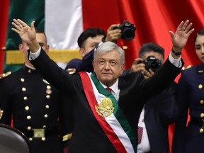 Newly appointed Mexican President Andres Manuel Lopez Obrador waves after being sworn in as the leader in Mexico City.