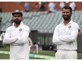 Man of the match India's Cheteshwar Pujara, right, stands with his captain Virat Kohli after his team's 31 run win over Australia to win the first cricket test in Adelaide, Australia,Monday, Dec. 10, 2018.