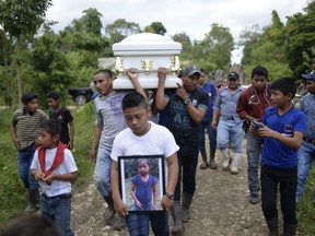 A boy carries a picture of Guatemalan seven-year-old Jakelin Caal, who died in a Texas hospital two days after being taken into custody by U.S. border patrol agents in a remote stretch of the New Mexico desert.