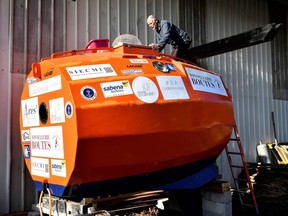 In this file photo taken on November 15, 2018 Jean-Jacques Savin, a former paratrooper, 71, works on the construction of a ship made from a barrel at the shipyard in Ares, southwestern France. -