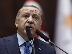 Turkey's President Recep Tayyip Erdogan addresses his ruling party's MPs at the parliament in Ankara, Tuesday, Dec. 25, 2018. Erdogan said Turkey was taking into account Trump's announcement on Syria rather than French President Emmanuel Macron's decision. Turkish Foreign Minister Mevlut Cavusoglu also said Tuesday Turkey is working with the United States to coordinate the withdrawal of American forces but remains "determined" to clear U.S.-allied Kurdish fighters from northeastern Syria.