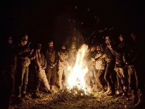 In this photo taken late Friday, Dec. 28, 2018, Turkey-backed Free Syrian Army soldiers wait stationed near the northern Syrian city of Manbij. Syria's military announced Friday that it entered the flashpoint Kurdish-held town of Manbij, where Turkey has threatened an offensive and raised the national flag there. (DHA via AP)