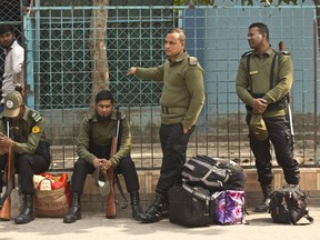 Bangladeshi police personnel with their belongings wait to accompany polling officials at a distribution center on the eve of the general elections in Dhaka, Bangladesh, Saturday, Dec. 29, 2018. As Bangladeshis get set for Sunday's parliamentary elections, there are fears that violence and intimidation could keep many away from the polls, including two opposition candidates who said police had barricaded them inside their homes.