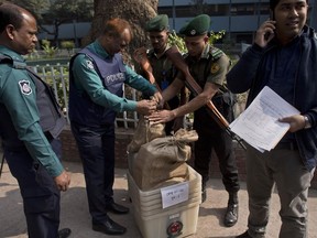 Bangladeshi police personnel seal the voting material at a distribution center before being transported to polling stations on the eve of the general elections in Dhaka, Bangladesh, Saturday, Dec. 29, 2018. As Bangladeshis get set for Sunday's parliamentary elections, there are fears that violence and intimidation could keep many away from the polls, including two opposition candidates who said police had barricaded them inside their homes.