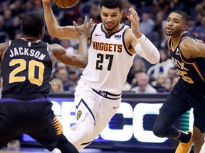 Denver Nuggets guard Jamal Murray (27) drives against Phoenix Suns forward Josh Jackson (20) during the first half of an NBA basketball game, Saturday, Dec. 29, 2018, in Phoenix.