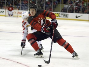 Team Canada's Owen Tippet holds off a Team Switzerland player during third period action in Victoria, B.C., on Wednesday, December 19, 2018. Canada won 5-3.