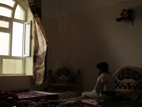 A boy sits on his bed in a rehabilitation center for former child soldiers in Marib, Yemen, in this July 28, 2018 photo. Children forced to fight in Yemen's civil war are often left traumatized, acting out aggressively and having panic attacks, some still bearing the mental scars from indoctrination by Houthi rebels who taught them to kill and die in a "holy war."