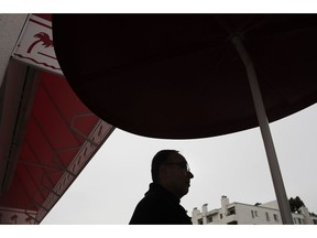 In this Wednesday, Dec. 5, 2018 photo, Father Jim Sichko stands outside an In-N-Out Burger, Wednesday, Dec. 5, 2018, in the Hollywood section of Los Angeles. The Catholic priest has a 50-state congregation and a simple mandate from the pope: Go forth and do good deeds. That's why Sichko found himself standing by the drive-through of the popular Hollywood fast-food joint on a windy, rain-swept recent afternoon buying lunch for everyone who stopped by.