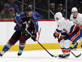 Colorado Avalanche left wing Gabriel Landeskog, left, passes the puck by New York Islanders right wing Jordan Eberle in the first period of an NHL hockey game Monday, Dec. 17, 2018, in Denver.