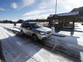 Motorists glide through the unattended toll booths at Rocky Mountain National Park Saturday, Dec. 22, 2018, in Estes Park, Colo. A partial federal shutdown has been put in motion because of gridlock in Congress over funding for President Donald Trump's  Mexican border wall. The gridlock blocks money for nine of 15 Cabinet-level departments and dozens of agencies including the departments of Homeland Security, Transportation, Interior, Agriculture, State and Justice.