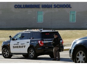 A member of the Jefferson County, Colo., Sheriffs Department stands guard outside the main driveway to Columbine High School Thursday, Dec. 13, 2018, in Littleton, Colo. Students were kept inside the building as a large police response was summoned because a caller claimed to have placed explosive devices in the school and was hiding outside with a weapon. The call was determined to be false.