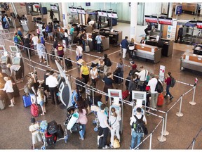Passengers wait to check in at Trudeau Airport in Montreal on July 19, 2017. Air passengers who are bumped from their flights because of overbooking, or forced to sit through long days will be able to receive up to $2,400 under proposed federal rules.