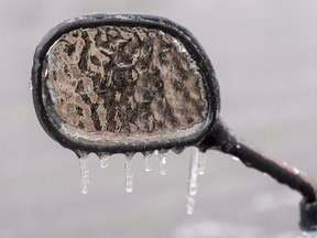 The ice-covered mirror of a a motorcycle is seen following freezing rain Monday, April 16, 2018 in Montreal. A wintry mix of snow, ice pellets and freezing rain is tracking eastward over Atlantic Canada today, with forecasters warning the low pressure system could interrupt holiday travel and threaten power lines.