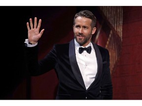 Actor Ryan Reynolds waves as he is introduced during a roast at Harvard University in Cambridge, Mass., Friday, Feb. 3, 2017. Canadian star Ryan Reynolds has outed himself as a Nickelback defender in a new trailer for his superhero flick "Once Upon A Deadpool."