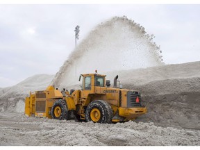 A snowblower piles snow at the city's newest dump at Blue Bonnets as snow removal operations continue in Montreal on February 14, 2018.
