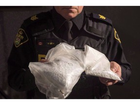 An OPP officer displays bags containing fentanyl as Ontario Provincial Police host a news conference in Vaughan, Ont., on February 23, 2017. Canada's chief public health officer says the need to increase access to a "safer supply" of opioids is being reviewed with provinces and territories, a move encouraged by a number of public health experts.