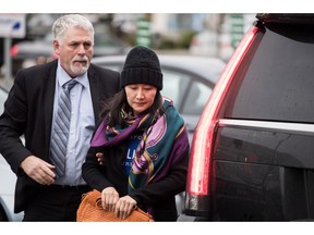 Huawei chief financial officer Meng Wanzhou, right, arrives at a parole office with a member of her private security detail in Vancouver, on Wednesday December 12, 2018.